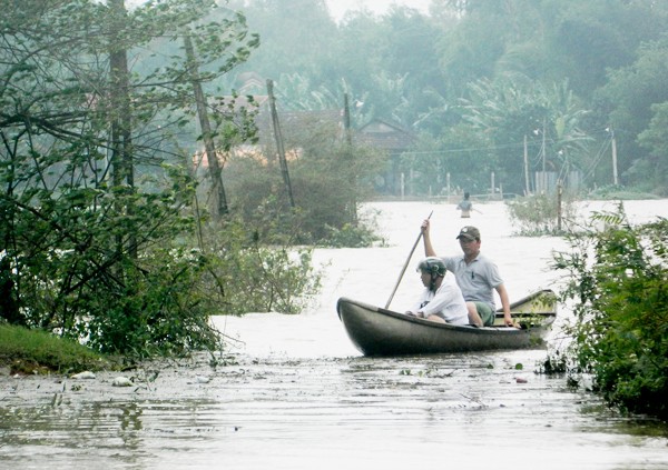 Flooding has stranded over 100 households in Binh Hiep commune, Binh Son district forcing them to travel by boats (Photo: SGGP)
